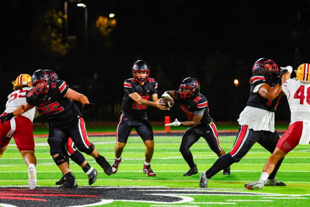 Eagle #16 Julian Silva hands the ball off to #28 Donovan Harvey