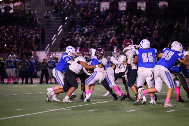 A swarm of West Valley Defensive linemen tackle running back #20 Aidan Freas in the backfield