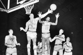 October 31. Fort Wayne's Mel Hutchins (9) and Syracuse's Earl Lloyd (11) reach for the ball during an NBA basketball game in Indianapolis, April 1955 Credit: AP