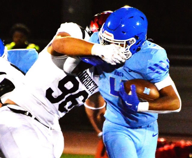 Murrieta Valley’s Wesley Gomes (96) has a hold of Norco running back Lee White’s facemask during the 3rd quarter of the Nighthawks’ 55 – 45 victory over the Cougars.