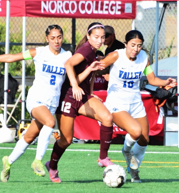 Featured Photos 10-03-2025. San Bernardino Valley College players Sienna Villalobos (2, left) and Faith Facio (10, right) scrunch Norco’s Leila Martinez (12) during the visiting Wolverines’ 2 – 0 victory over the Mustangs in Norco.