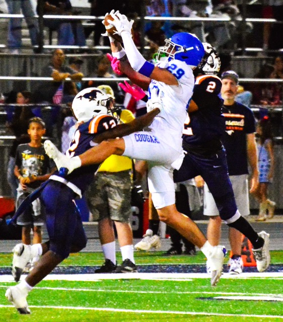 Norco’s Joshua Cobian (29) leaps for an interception between Roosevelt receivers Darion Rubin (12) and Nathan Ramirez (2). 