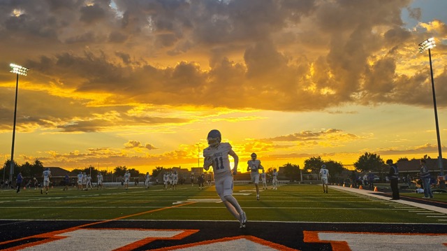 Friday Night Lights frames a stunning All-American tableau in Eastvale as Norco’s Riley Scheppmann (11) warms up before a gridiron clash of Cougars and Mustangs. Photos, Page 16. Credit: Photo by Gary Evans