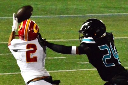 Corona receiver Benjamin Campusano (2) has a step on Santiago defender Khalil Page (24), but the ball slipped through his fingertips during this second-quarter play. The Sharks defeated the Panthers 37 – 21. Credit: Photo by Gary Evans