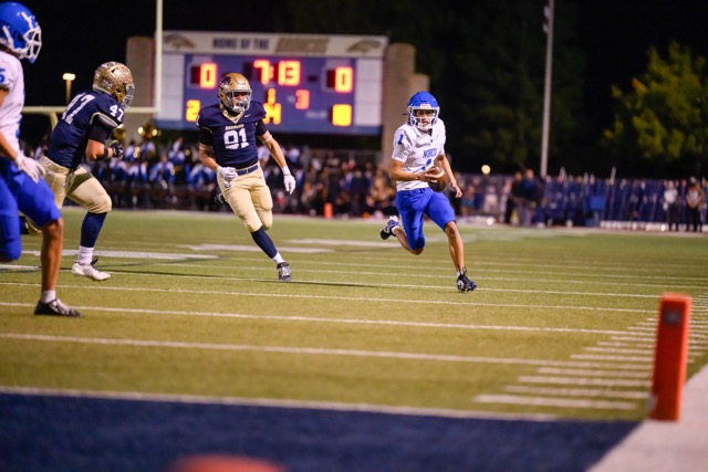 Norco QB #1 Julian Medina scrambles out of the pocket to gain a few yards on a broken play, while being tracked by Akai Alvarez (91) and Joshua Baker (47) of Vista Murrieta.