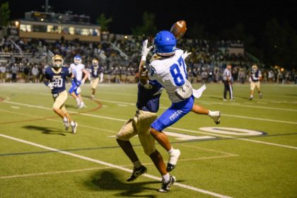 Cougars wideout Joey Gear (87) attempts a spectacular catch over a Broncos defender.