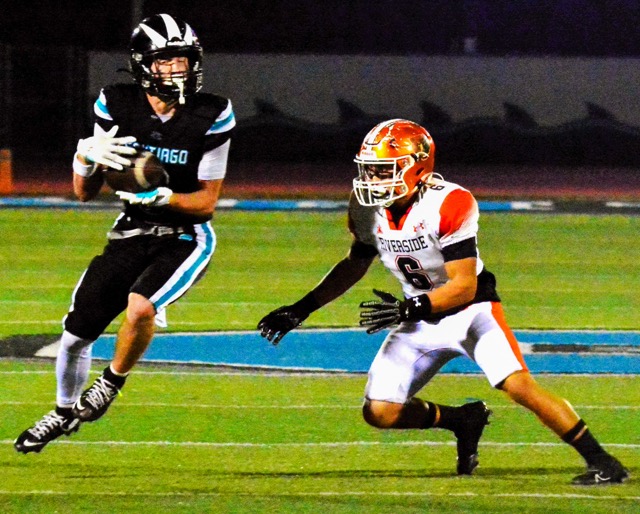 Corona Santiago’s Drake Zimolzak (0) catches a pass from Quarterback Clayton Plewe while Riverside Poly defender Jace Bahena (6) comes up to make the tackle
