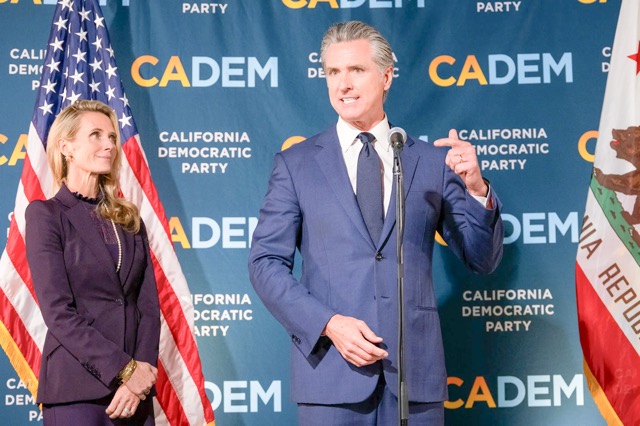 Prop 50 Gov. Gavin Newsom speaks to the press, alongside his partner Jennifer Siebel Newsom, after Proposition 50 was passed by California voters, at the California Democratic Party headquarters in Sacramento on Nov. 4, 2025. 
Credit: Photo by Jungho Kim for CalMatters
