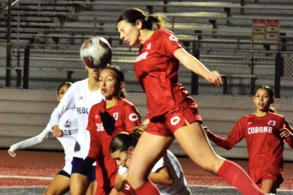 Corona’s Vanessa Diaz (11) leaps for a header as teammate Giselle Fuentes-Gonzalez (13) reflexes.