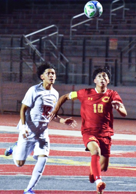 A Hemet player and Corona’s Rooney Rodriguez (right) eye the bouncing ball during the Panthers’ come-from-behind 3 – 1 victory over the Bulldogs.