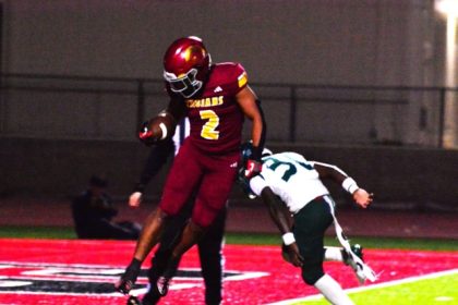 Hillcrest running back Reyez Ortiz (2) flies into the end zone for a touchdown after evading Tahquitz defender William Butler (30). The Trojans defeated the Titans 63 – 34 to claim the CIF Division 10 championship.