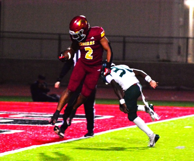 Hillcrest running back Reyez Ortiz (2) flies into the end zone for a touchdown after evading Tahquitz defender William Butler (30). The Trojans defeated the Titans 63 – 34 to claim the CIF Division 10 championship.