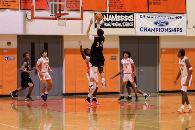 West Valley’s #34 Jamessen Lima jumps up and over the defender to make a quick one handed dump