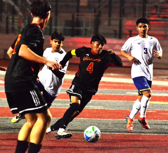 Corona’s Edwin Carbajal (4) dribbles past Riverside North players towards a shot on goal.