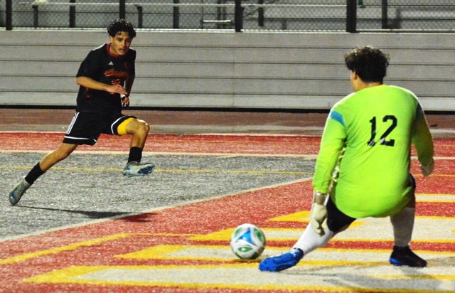 Corona’s Micah Bejarano (7) blasts a shot that the Riverside North goalie (12) deflected away with his left foot.