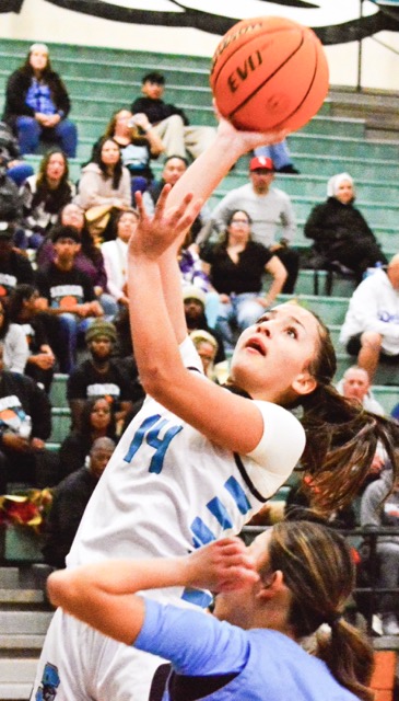 Corona Santiago’s Madison Self (14) goes for a layup over Norco’s Sinclair Smith during the Sharks 60 - 19 win over the Cougars.