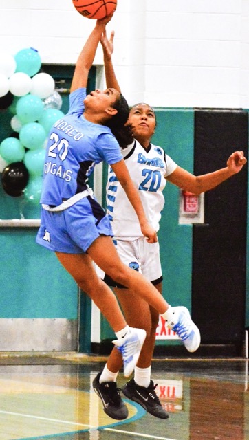 Norco’s Mya Smith (20) and Santiago’s Manniyah Culver-Stowe (20) stretch for a high pass during the Sharks 60 – 19 victory over the Cougars.