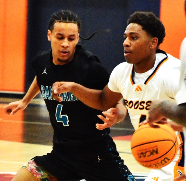 Corona Santiago’s Jaden Berry (left) chases Eastvale Roosevelt’s Jackson Haggins (right), dribbling towards the basket. The Sharks defeated the Mustangs 70 – 63.
