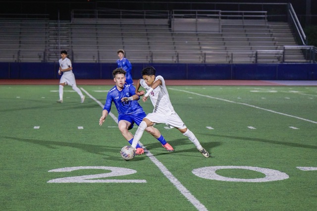 West Valley’s #4 Bryan Teran dribbles past a Titans #14 Cesar Sferlazza in the midfield