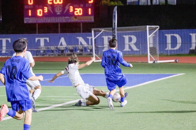Mustangs #17 Diego Gomez executes a slide tackle