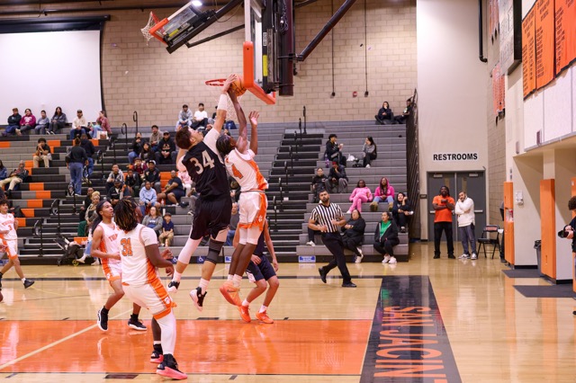 Mustangs #34 Jamessen Lima splats the layup attempt from Tigers #4 DeSean Gilmore against the backboard