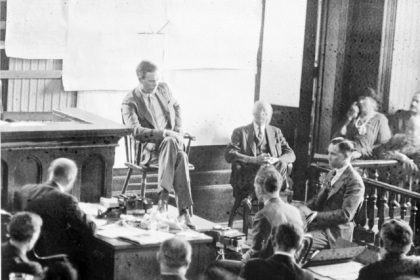 February 13. . Lindbergh testifying at Hauptmann's trial. Hauptmann is in half-profile at right. Credit: Library of Congress