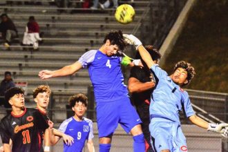 Norco’s Alonso Luna (4) skies for a header on goal while Corona goalie Chris Salazar (1) tries to punch the ball away. The Cougars handed the Panthers their first loss of the season with a 2 – 1 victory. Left to Right: Corona’s Isaiah Ramirez (11), Martin Nunez, and Norco’s Alex Cervantes (9) watch the action.