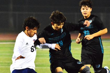 Eastvale Roosevelt’s Eduardo Nuno (6) and Corona Santiago’s Nathan Navarijo (center) battle for the ball while Edgar Regalado (30) pursues the play during the Sharks 2 – 1 victory over the Mustangs.