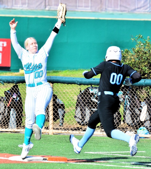 The shadow suggests Aliso Niguel first baseman Evie Scherffius’ right toe may be (please leave italics in) off the bag as she stretches and snares the throw as Norco’s Savannah Gonzalez reaches for the bag. In the double-zero-sum moment, Gonzalez was ruled safe.