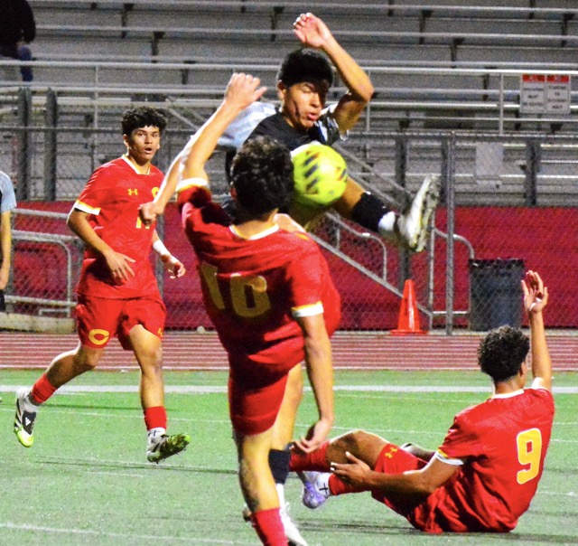 Corona’s Julian Sanchez (left) watches teammate Rooney Rodriguez (10) and Centennial’s Andres Araiza (top) fight for the ball while Julian Sanchez (9) calls for a foul during the Panthers’ 1 – 0 victory over the Huskies.