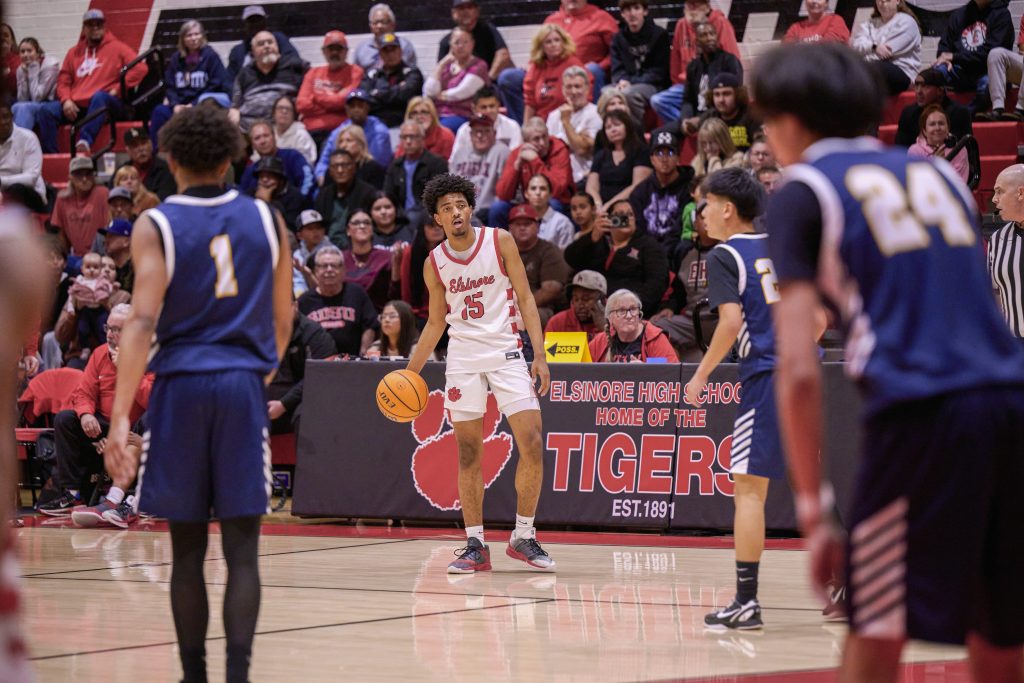 Featured Photos 02-13-2026. The Elsinore Tigers defeated the Sonora Raiders 80-78 in the first round of the CIF Southern Section D2A playoffs on Wednesday. Elsinore plays the Hesperia Scorpions tonight. Corona Santiago goalie Ellie Baker (top) eyes the ball while Los Al’s Hailey Rippeon (6) gets ready to throw on goal. Savannah Perez (bottom) and Riley Romero (right) defend on the play.