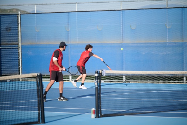 Patriots duo returns a volley with a gentle backhand to keep the ball close to the net