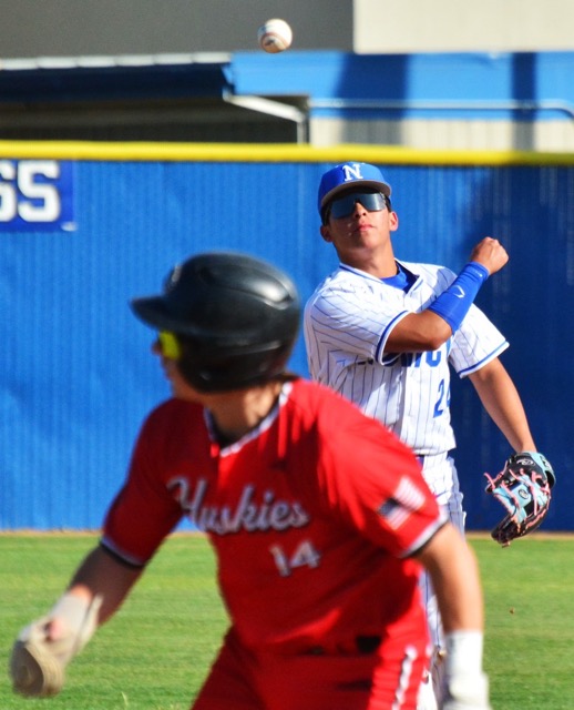 Norco’s Zion Martinez (top) snagged an ankle high line drive for an out, and throws to first to double up Centennial runner Michael Nonis (14).  The Cougars defeated the Huskies 8 – 4.