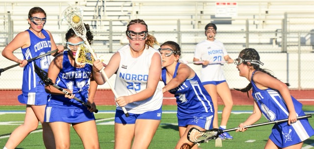 Norco’s Hailey Grinde (23) cradles the ball in her crosse as four Culver City players trail and teammate Paige Daly (20) looks on. The Cougars’ offense roared as they overwhelmed the Centaurs in a non-league match.
