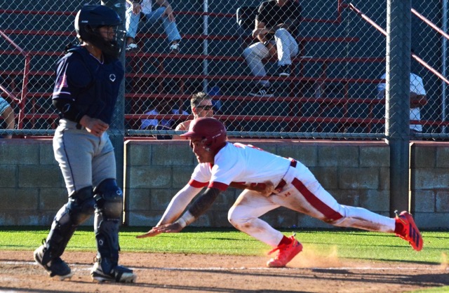 Corona’s Jesiah Andrade slides in home while the Riverside King catcher watches the throw go to second base.