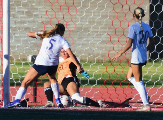 Eastvale Roosevelt goalie Giulianna Vargas (00) slides to block the shot from Newport Harbors Mia Knox (5), preserving the slim 1 – 0 lead. Cassie Jacoby (20) was also poised for the rebound that didn’t come.