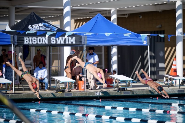 Swimmers explode off the blocks to begin a heat during Wednesday’s meet at Liberty High School.