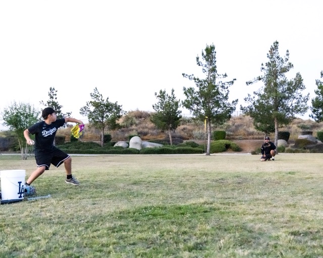 Elmer, dad, catches for son, Anthony, 9, who is about to fire a 4 seam fast ball at Spirit Park in Menifee on Wednesday. 
Credit: Lisa Zambrano
