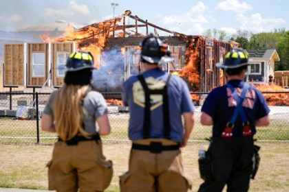 Chester County Firefighters Elizabeth Stevenson, from left, Michael Mackey and Charles Lee, watch an accessory dwelling unit burn during an experiment at the Institute for Business & Home Safety center in Richburg, S.C. Credit: AP Photo/Erik Verduzco