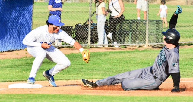 Santiago’s Troy Randall is sliding into an out applied by Norco third baseman Jordan Ayala, who received a throw from centerfielder Elijah Alvarez, who caught a fly out and then doubled up Ayala, who tagged up. The Cougars defeated the Sharks Monday evening, 3–1, in the first game of the week’s three game series.