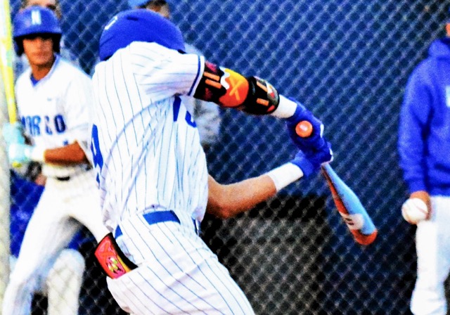 Norco’s Jayden Serna connects on an infield hit against Santiago. The throw was wide of first, allowing Serna to advance to second base.