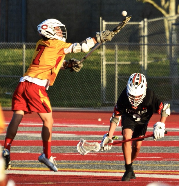 Featured Photos 04-03-2026. Corona’s Mason Maros (7) leaps for the ball after a face-off with Segerstrom’s Isaih Barbono during the Panthers 15 – 0 pasting of the Jaguars.