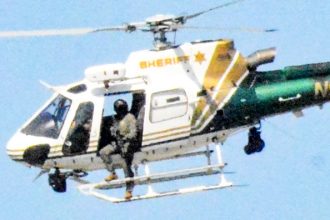 Chase Suspect Killed. Riverside Sheriffs picked up the pursuit from CHP, including from the air. While shots were not believed to have been fired from a sheriff’s pursuit helicopter, an officer was observed outside on the strut with what appears to be a long gun. The Progress/Sentinel has inquired about the department’s policy regarding the potential of firing shots from the air, and will report the answer when received. Credit: Photo by Gary Evans