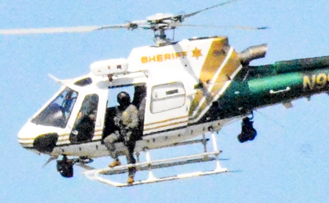 Chase Suspect Killed. Riverside Sheriffs picked up the pursuit from CHP, including from the air. While shots were not believed to have been fired from a sheriff’s pursuit helicopter, an officer was observed outside on the strut with what appears to be a long gun. The Progress/Sentinel has inquired about the department’s policy regarding the potential of firing shots from the air, and will report the answer when received. Credit: Photo by Gary Evans