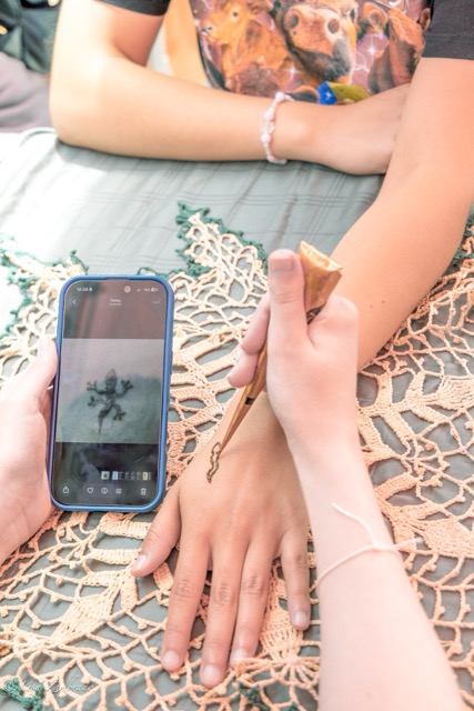 Henna artist Elsa Park draws a salamander on Environmental club member Sopia Casa’s hand at Mt. San Jacinto College in Menifee on Earth Day, Wednesday 22, 2026.