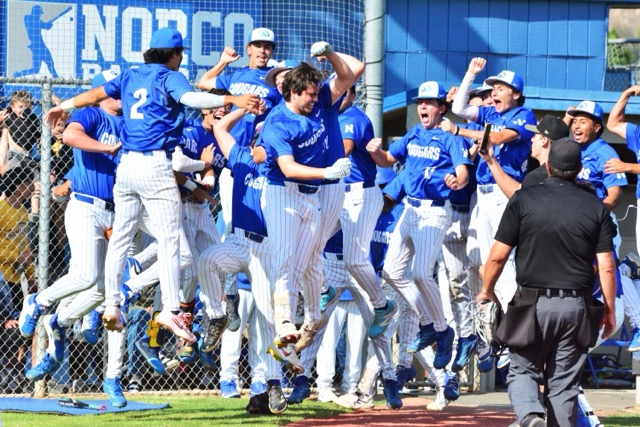 The Norco baseball team leaps in celebration with Jacob Melendez (center), who just blasted a two-run home run to give the Cougars a 5 – 2 lead over visiting Notre Dame/Sherman Oaks in the CIF Division 1 semi-final game. Norco will face Bosco tonight (Friday) at Cal State Fullerton for the championship