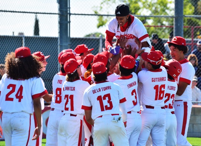 Corona’s Anthony Murphy is lifted high in the air by his teammates after hitting a lead-off home run in the bottom of the first against Norco.