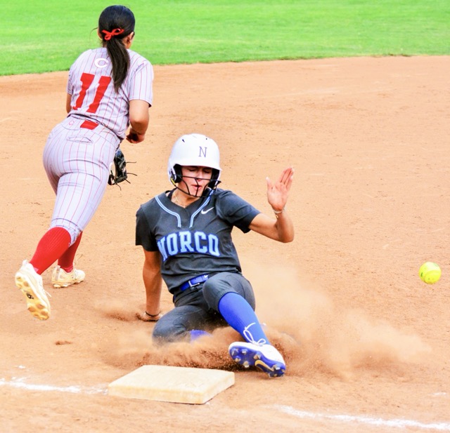 Corona third baseman Savannah Fuentes (11) was unable to handle the throw as Norco’s Rae Logue slides into third safely on a single by Kayla Stucky. The Cougars beat the Panthers 12 – 1.