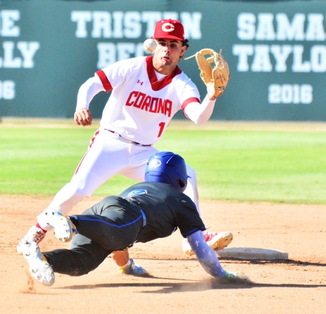 Corona shortstop Trey Ebel (top) eyes the ball before making the catch and tag of Norco’s Dylan Seward (2) as he tries to steal second base.