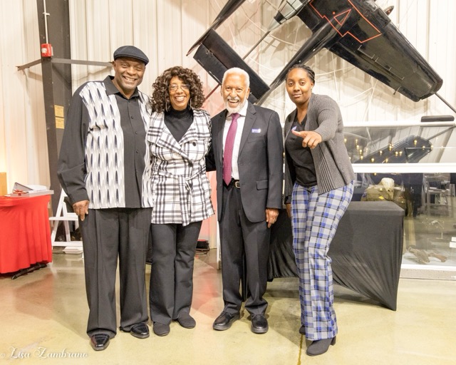 (Right to left) Tiffany Lewis and Chuck Washington pose next to two attendees in front of one of the dozens of exhibits. This one is the Northrop P-61 Black Widow Night-Fighter. Credit: Photo by Lisa Zambrano